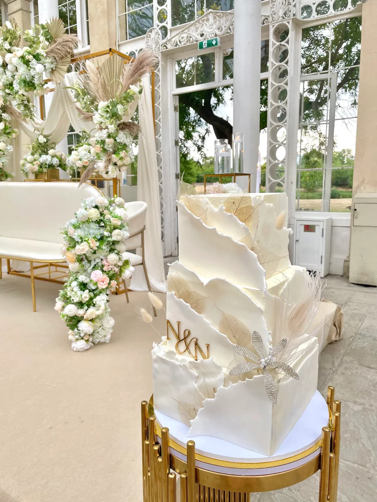 A white celebration cake surrounded by flowers
